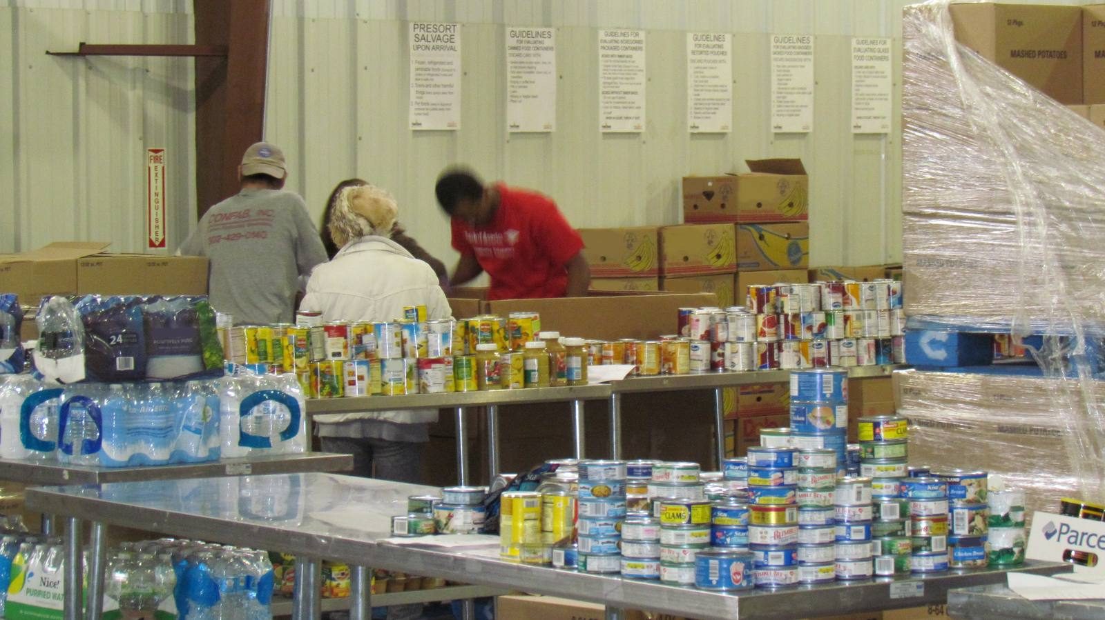 Volunteers sorting canned goods at a food bank.