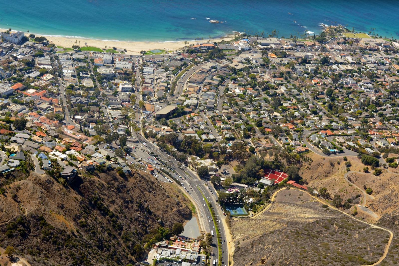 An aerial view of downtown Laguna Beach and Main Beach under clear skies, where the extreme heat warning promises mid-80s to low-90s afternoons through Thursday.