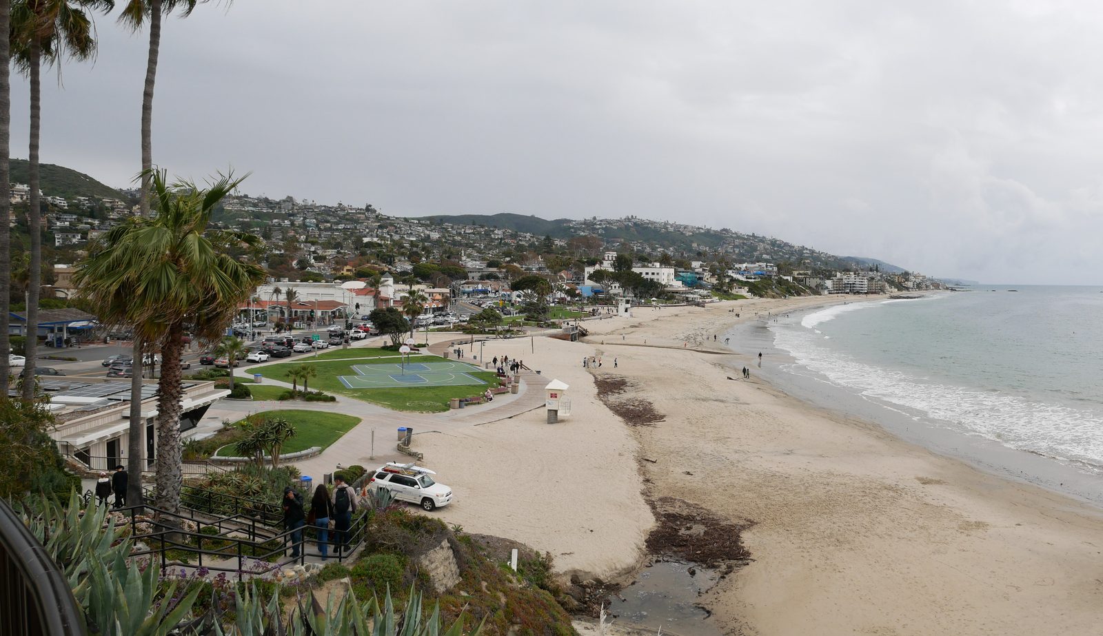 Main Beach under a marine layer, at the heart of the visitor economy behind the hotel tax debate.