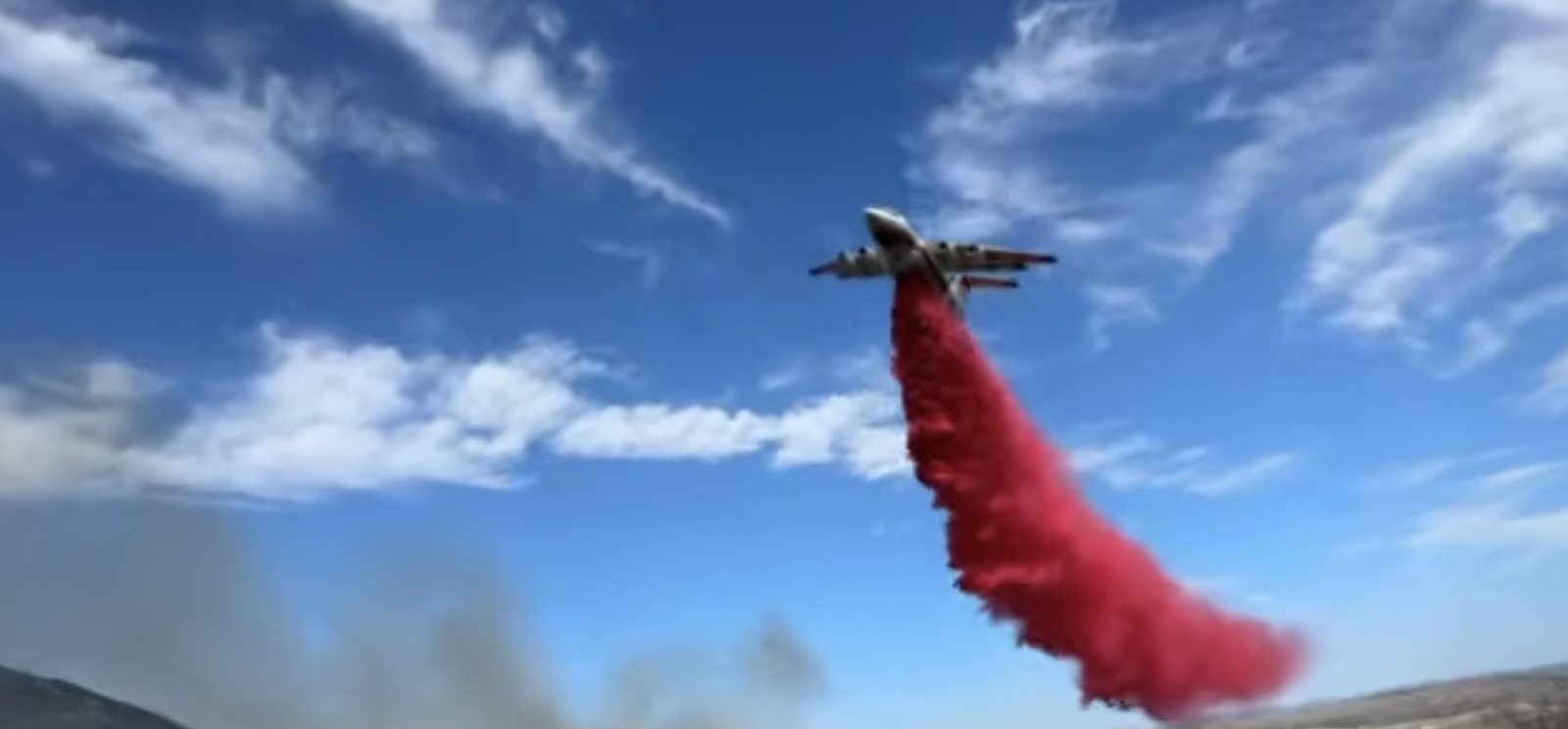 An air tanker drops a load of retardant on the Norte Fire on Friday, with smoke rising from the hills below. Tankers and helicopters worked the fire from the air while ground crews built the containment lines that reached 80 percent on Monday.