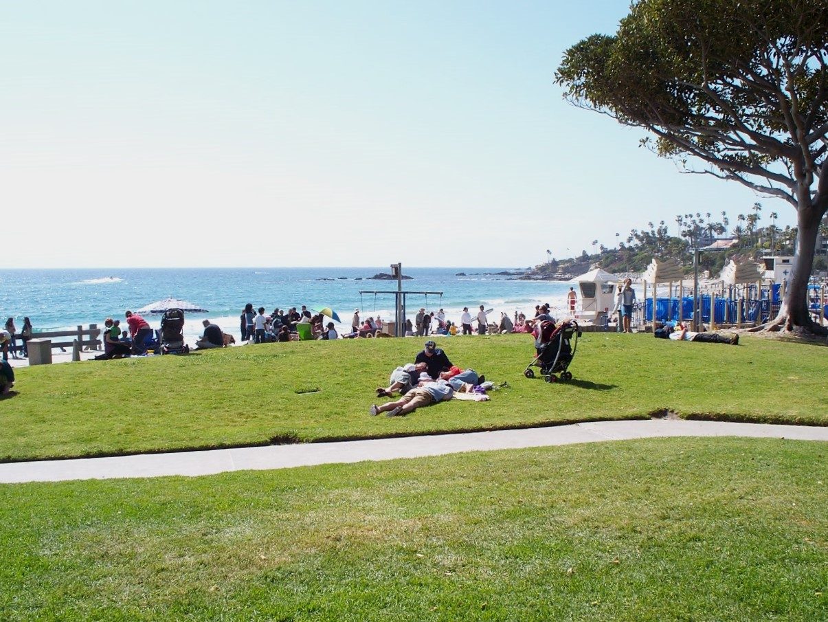 Visitors relax on the Main Beach lawns as October festival season fills the town.