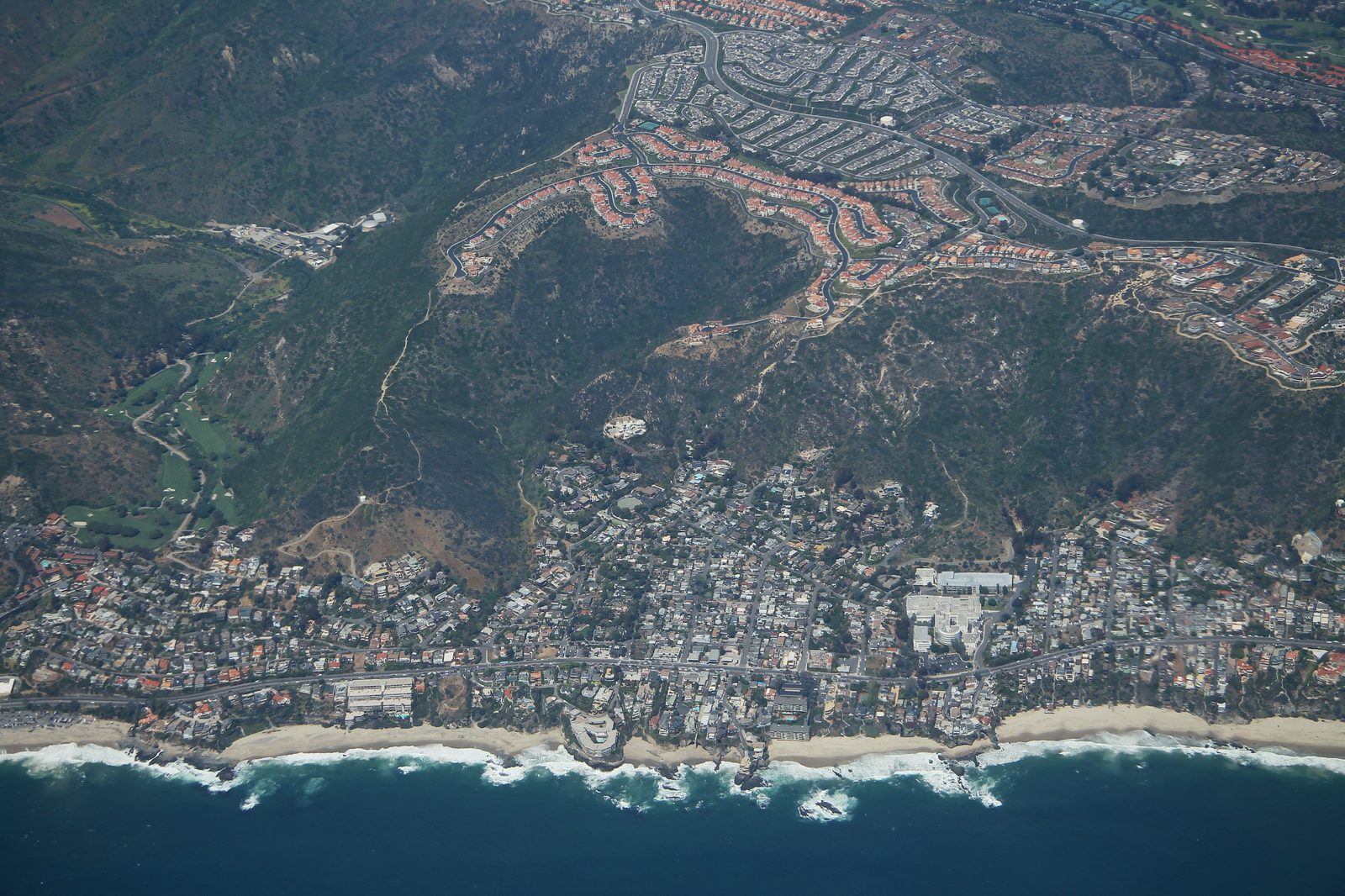 An aerial view of Laguna Beach, where hillside homes meet open chaparral on every side.